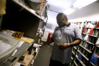 E.B. Brown, lead sales and service agent at the University Station Post Office, sorts packages.