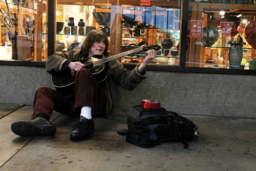 Cold play: Bruce Windham, seen here busking with guitar, has been playing both guitar and violin for six years.