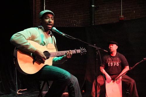 Acoustic storytelling: Parfait Bassale, left, performs at Northwest Portland’s Someday Lounge, accompanied by Amor on Cajon.