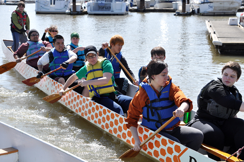 Going swimmingly: The Green Dragons take a practice boat out on a sunny Saturday morning. Club captain Dominic Lemas, in the back, steers the boat out into the Willamette.