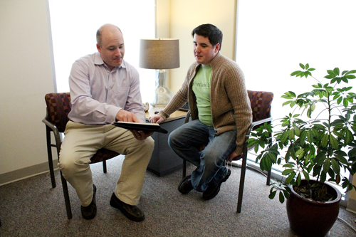 Dana Tasson, executive director of SHAC (left), speaks with Nick Poublon, chair of the student health advisory board.