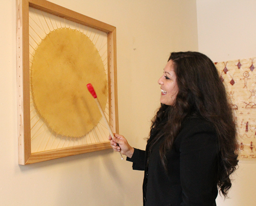 Rochelle Kulei Nielsen plays a wall-mounted rawhide drum.