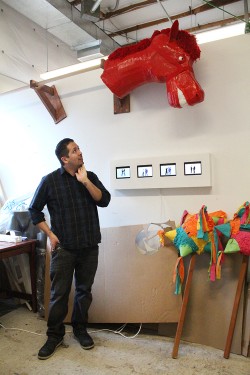 Sam Guerrero studies a piñata in his studio.