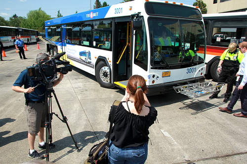 The wheels on the bus go round and round: TriMet employees and members of the press look at the new bus prototype.