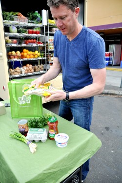 Promoting the wares: My Street Grocery co-founder Eric Johnson sets up a display next to the grocery truck.
