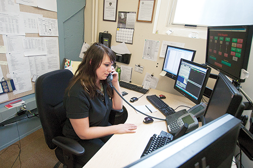Dispatcher Bonnie Jensen answers phones at CPSO in Shattuck Hall. Photo by Adam Wickham.