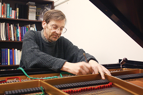 Bruce Lindley, who tunes all the pianos in the music department, has been tuning pianos for 40 years. Photo by Cassandra Moore.