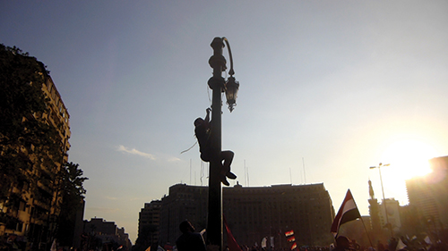 A protester climbs a light pole in Tahrir square in downtown Cairo. Seth Thomas was able to snap this photo and snare it on his blog for his capstone course. Photo courtesy of Seth Thomas.