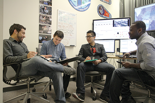 From left: Ryan Jenson, E-Club President Nick Simms, Treasurer Heber Miguel and Vice President Enoch Aggrey dialogue at the Entrepreneurship Club’s weekly meeting. SALP helped the club get off the ground. Photo by Kayla Nguyen.