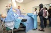 Erica L. Mitchell, M.D. of the School of Medicine Vascular Surgery, explains to visitors the features of the surgery simulation room. Photo by Christopher Sohler